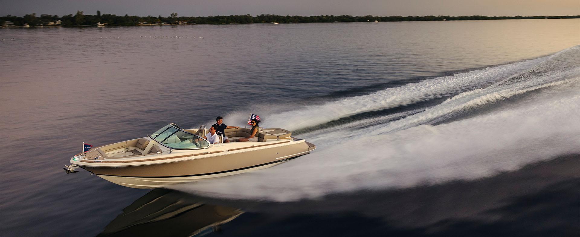 People riding on a Chris Craft speedboat in the water